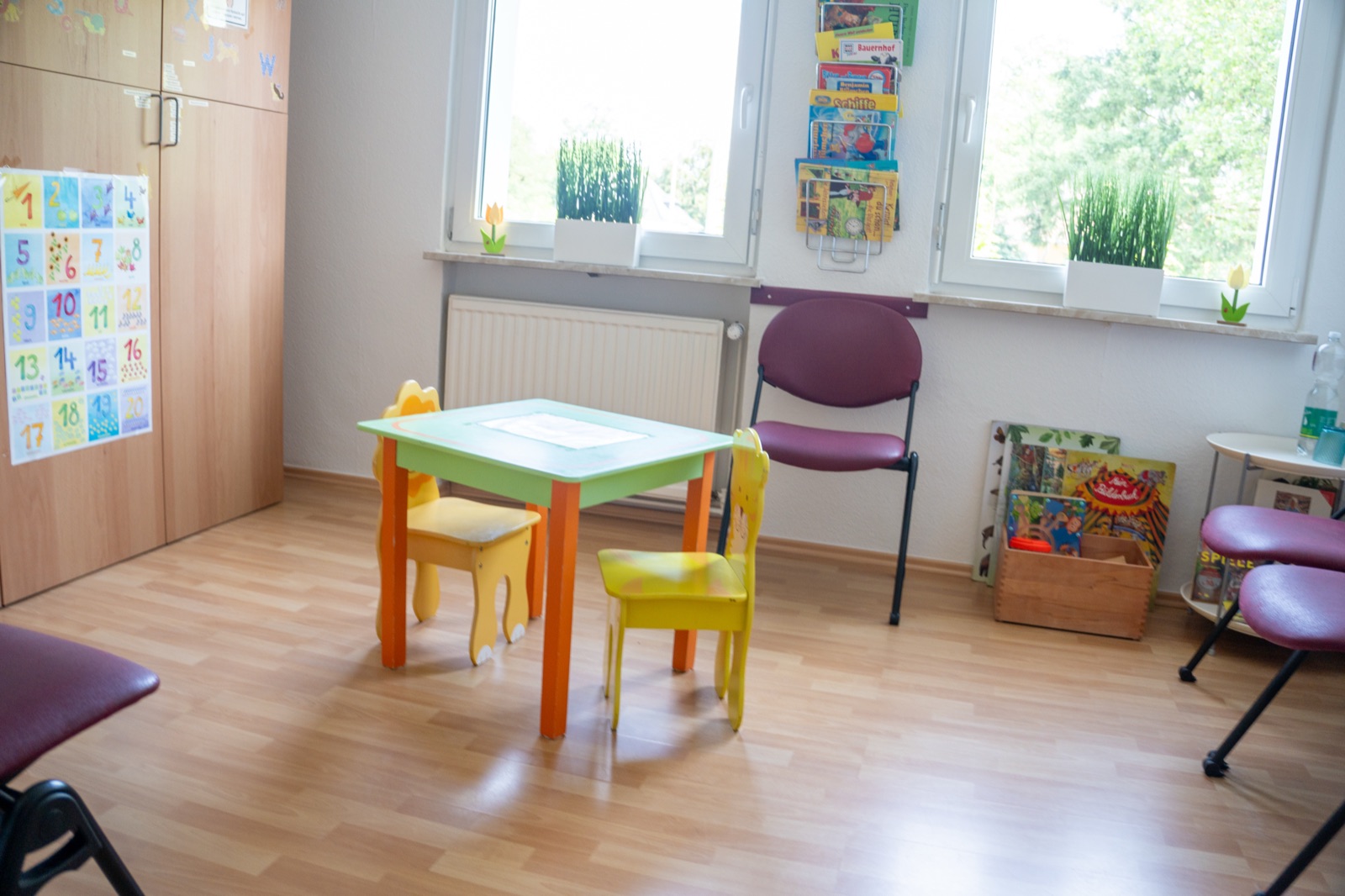Therapieraum mit Kindertisch, Bilderbüchern und Lernpostern